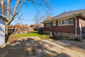 View of side of home featuring brick siding and roof with shingles