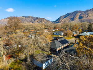 Aerial view of property and surrounding area featuring a mountainous background