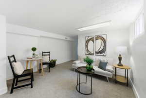 Living area featuring light colored carpet and a textured ceiling