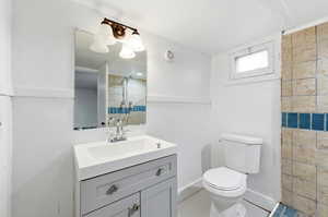 Full bathroom featuring vanity, tiled shower, and light tile patterned flooring