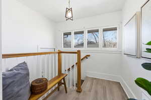 Stairs featuring wood finished floors and healthy amount of natural light