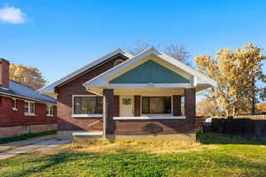 Bungalow-style home featuring covered porch and brick siding