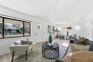 Living room featuring light wood-type flooring and a textured ceiling