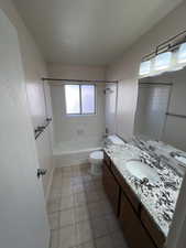 Full bath featuring tub / shower combination, vanity, and light tile patterned floors