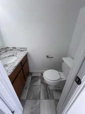 Bathroom featuring vanity and light marble finish flooring