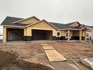 Property in mid-construction featuring a shingled roof