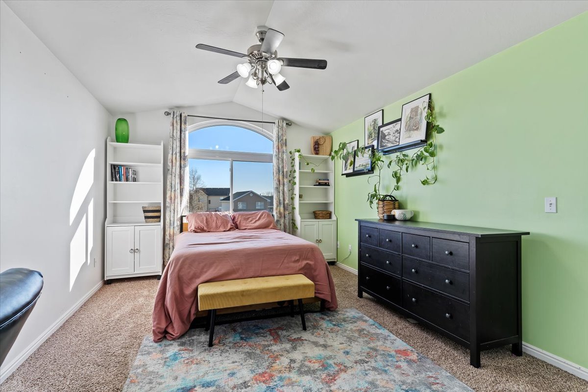Primary bedroom featuring lofted ceiling and ceiling fan
