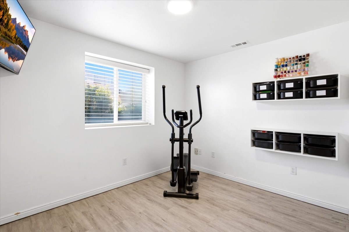 Versatile interior space featuring light wood-finish flooring, white walls, and a recessed ceiling light