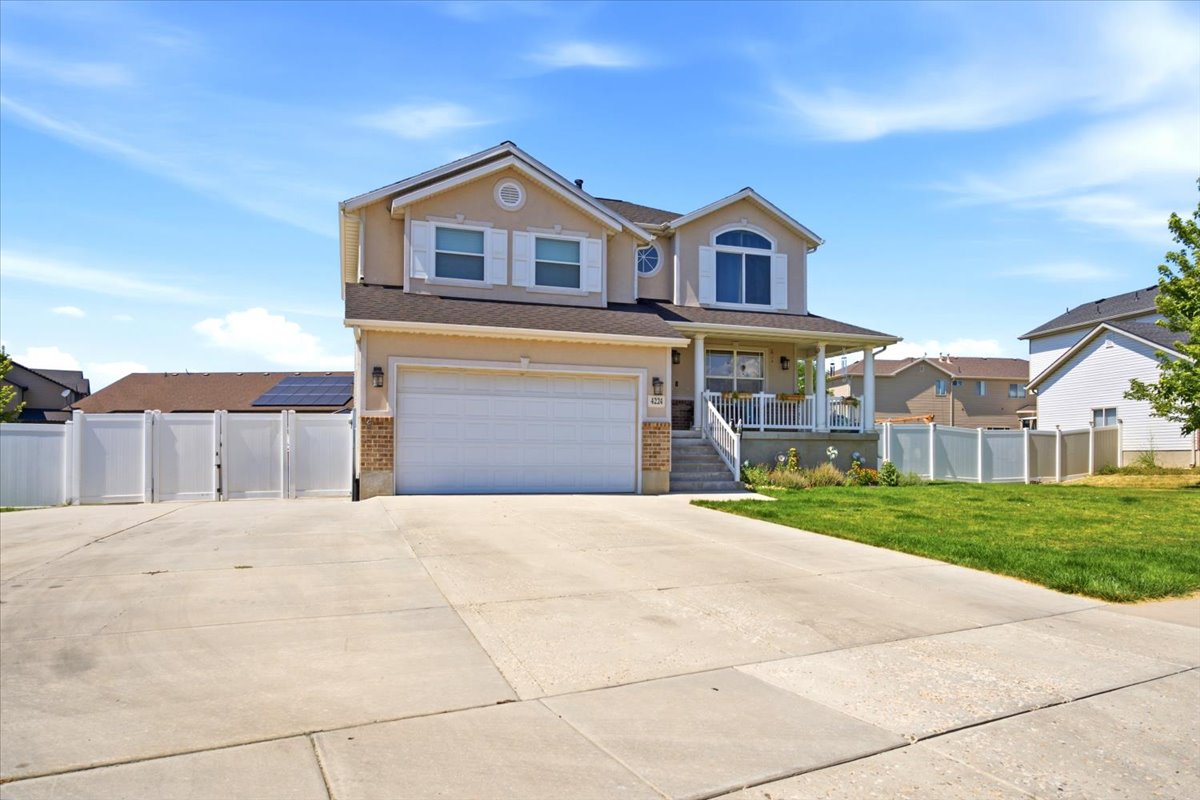 Two-story residence featuring a covered front porch, an attached garage, and a concrete driveway