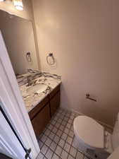 Half bath featuring vanity and light tile patterned floors