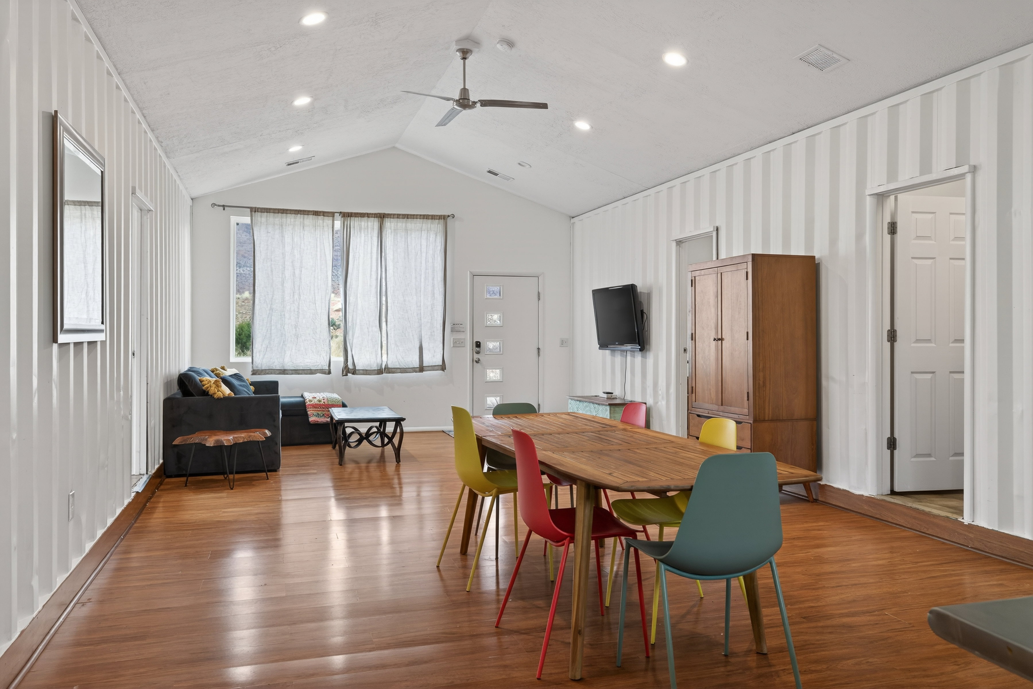Dining area featuring a ceiling fan, wood finished floors, recessed lighting, and a high ceiling