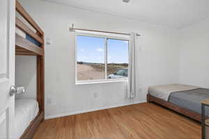 Bedroom with wood finished floors and baseboards