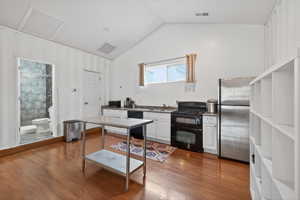 Kitchen featuring black appliances, white cabinetry, and light wood-type flooring