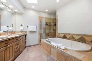 Bathroom with double vanity, a garden tub, a stall shower, and recessed lighting