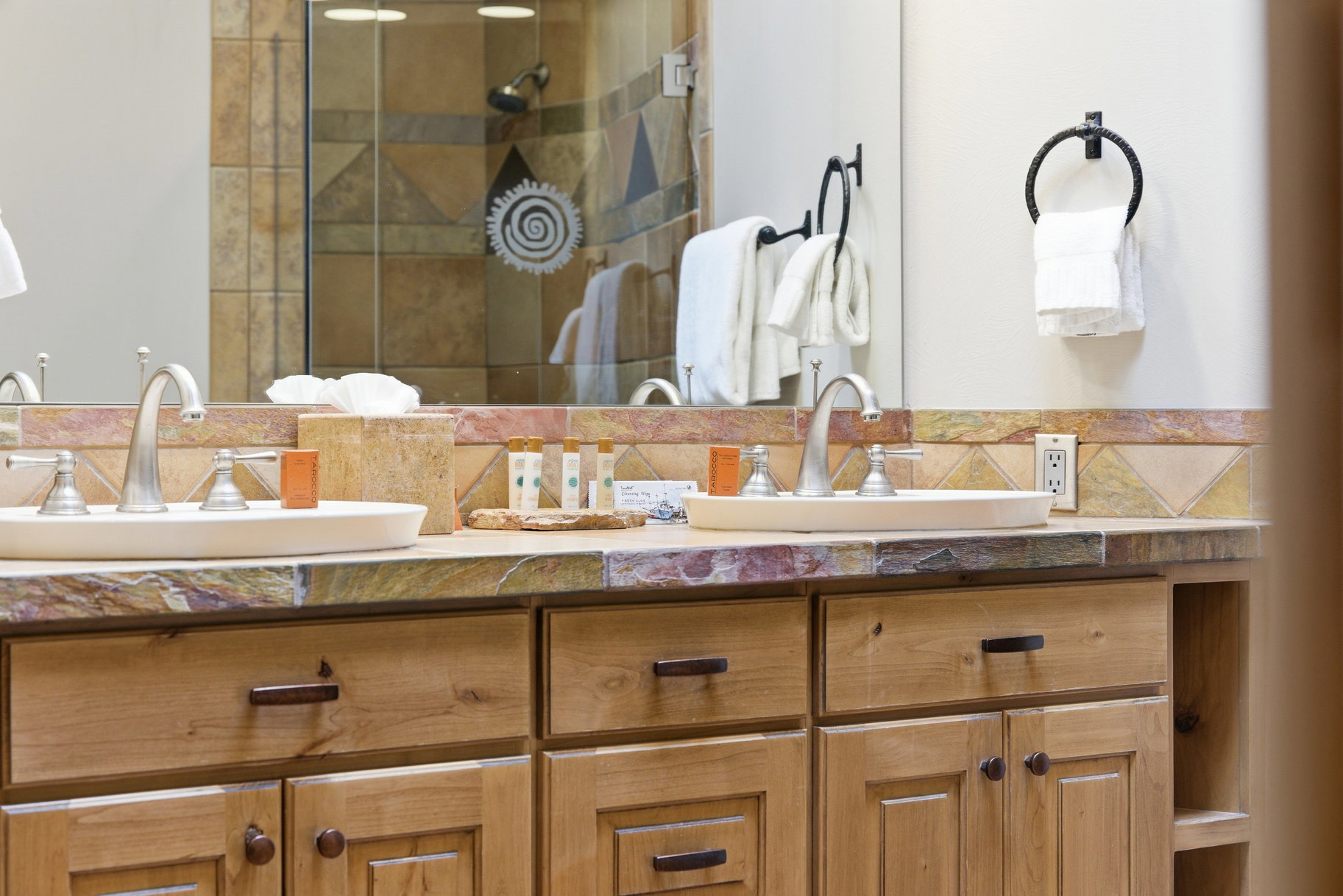Full bathroom with double vanity and a shower stall