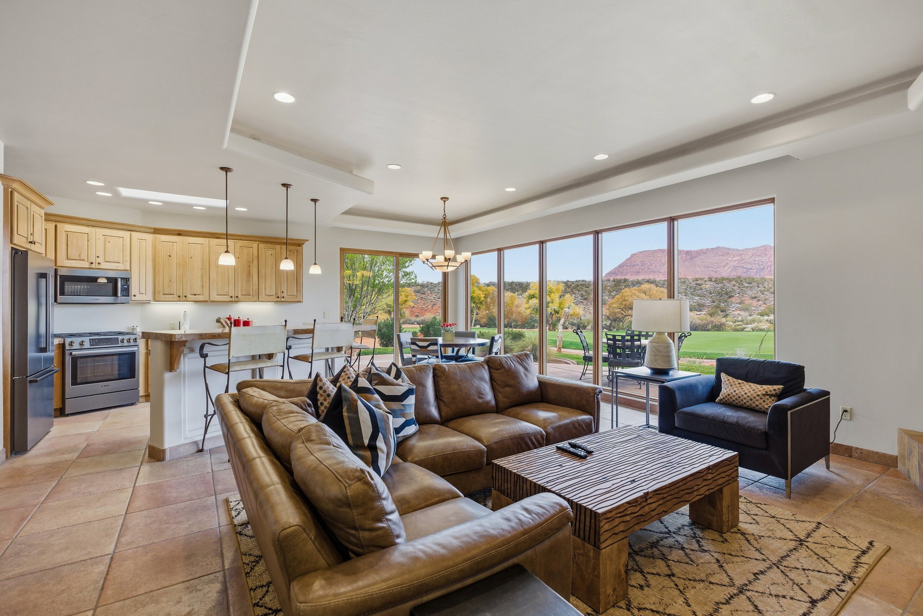 Living area featuring a raised ceiling, a chandelier, a mountain view, recessed lighting, and light tile patterned flooring