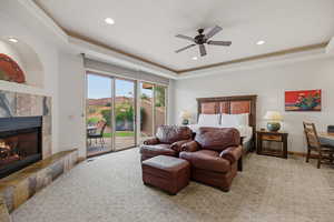 Bedroom featuring access to outside, a tray ceiling, light carpet, and recessed lighting