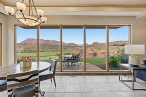 Sunroom / solarium with a mountain view, a chandelier, and tile patterned floors