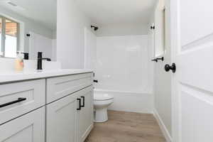 Bathroom featuring vanity,  shower combination, and light wood-type flooring