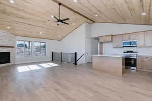 Kitchen featuring open floor plan, appliances with stainless steel finishes, a center island, recessed lighting, and light wood-style flooring