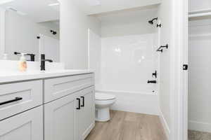 Full bathroom with vanity, bathing tub / shower combination, and light wood finished floors