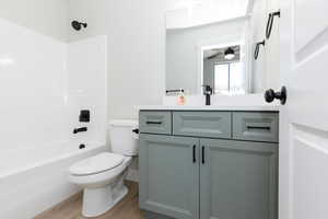 Bathroom featuring vanity, washtub / shower combination, light wood-type flooring, and ceiling fan