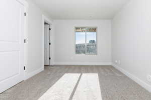 Spare room with baseboards and light carpet