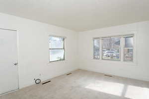 Unfurnished room with carpet and a textured ceiling