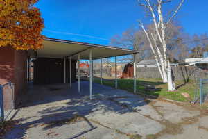 View of vehicle parking with a storage shed, a carport, and concrete driveway
