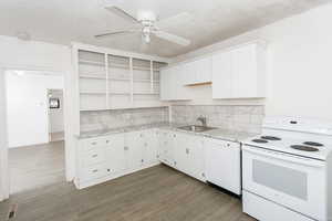 Kitchen featuring white appliances, open shelves, white cabinets, dark wood finished floors, and a ceiling fan
