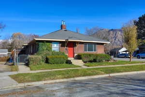Bungalow with a chimney, roof with shingles, stucco siding, a gate, and a mountain view