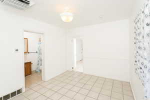 Unfurnished room with cooling unit and light tile patterned floors