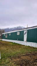 View of front of property with a mountain view and a front yard