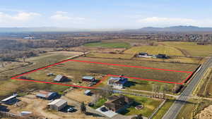 Overview of rural landscape featuring mountains, property parcel outlined, and large plots for crops