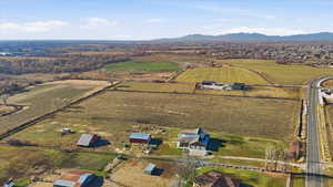 Aerial view of property and surrounding area with rural landscape, a mountainous background, and farmland