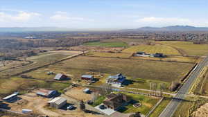 Aerial view of property and surrounding area with a mountain backdrop and rural landscape