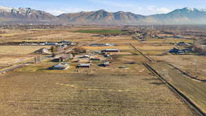 Aerial view of property and surrounding area with a mountainous background and rural landscape