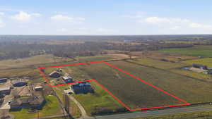 Aerial view of sparsely populated area featuring property parcel outlined