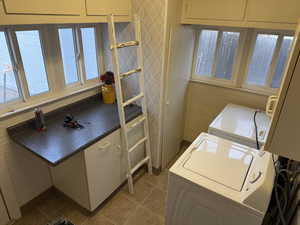 Washroom featuring washing machine and clothes dryer and dark tile patterned flooring