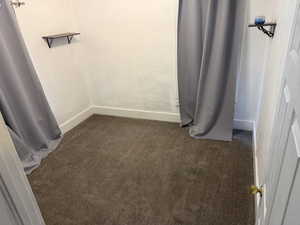 Walk in closet with dark carpet