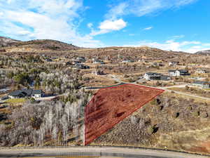 Aerial view of property and surrounding area featuring a mountainous background and property parcel outlined