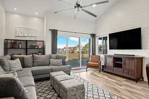 Living room featuring high vaulted ceiling, light wood-style flooring, recessed lighting, a ceiling fan, and a residential view