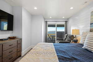 Bedroom featuring access to outside, wood walls, and recessed lighting