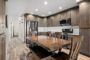 Dining space with light wood-style floors and recessed lighting