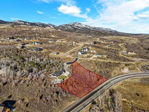 Aerial overview of property's location with a mountain backdrop and property boundaries highlighted