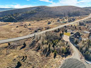 Aerial view of property and surrounding area with a mountain backdrop