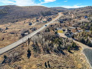 Aerial view of property and surrounding area featuring a mountain backdrop