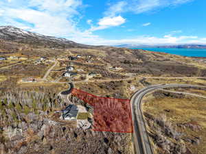 Aerial view of property and surrounding area with mountains and property parcel outlined
