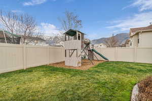 Fenced backyard with a fun playset