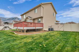 Rear view of house with a gate, a deck with mountain view, and a playground